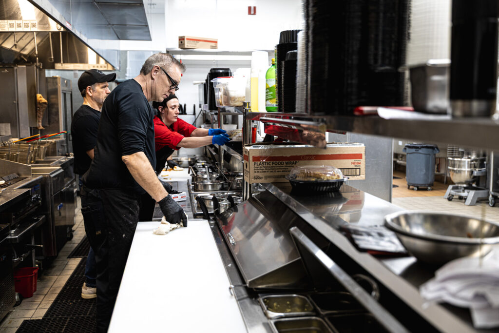 Fire & Feast cooks and kitchen staff preparing fresh meals and catering orders on the kitchen line in Commerce Township, Michigan.