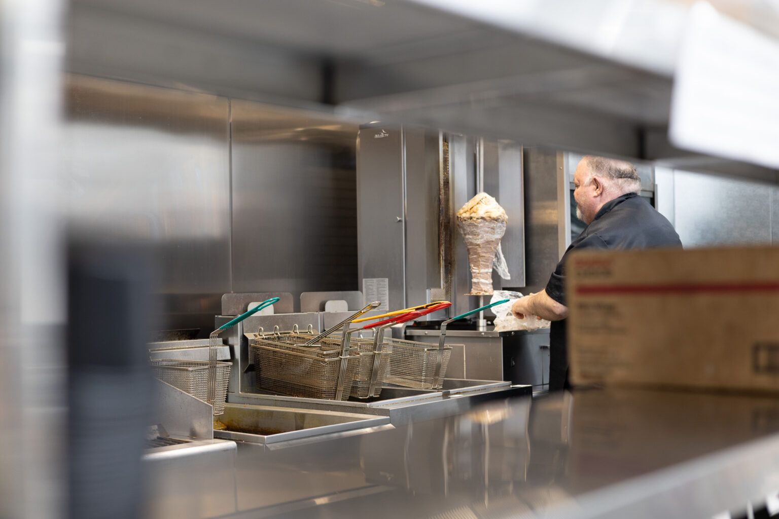 Fire & Feast chef preparing fresh made-to-order meals in a commercial kitchen in Commerce Township, Michigan.
