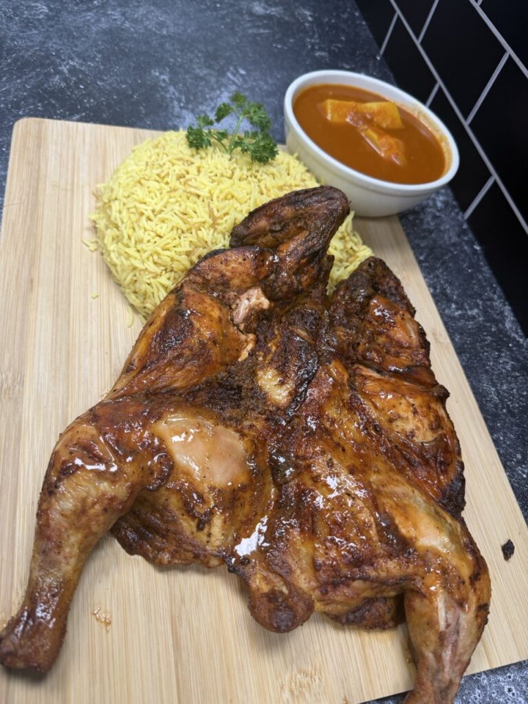 Golden roasted whole chicken seasoned with herbs and spices and prepared fresh at Fire & Feast in Commerce Township, Michigan.