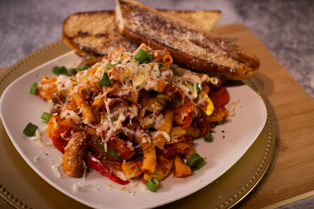 Fire & Feast Ziti Cerveno featuring ziti pasta with fresh vegetables, marinara sauce, melted mozzarella, and Parmesan cheese in Commerce Township, Michigan.
