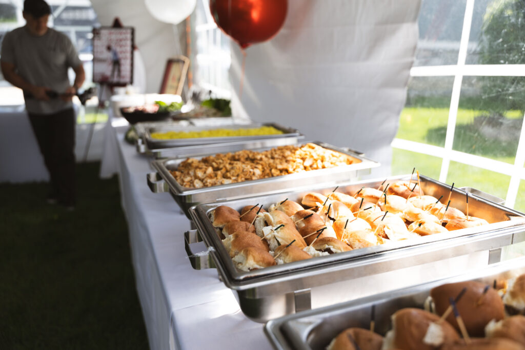 Fire & Feast catering buffet with professional chafing dishes filled with fresh Mediterranean specialties and American favorites at a private event in Commerce Township, Michigan.